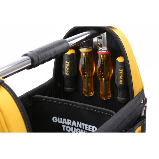 Close-up of a DEWALT tool bag containing several DEWALT screwdrivers with yellow and black handles, organized in a vertical pocket. The words 'GUARANTEED TOUGH' are visible on the inner fabric.