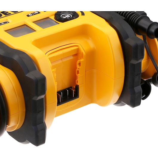 Close-up view of a DEWALT DCC018N portable air compressor, showing the battery compartment with black and yellow casing and control buttons.