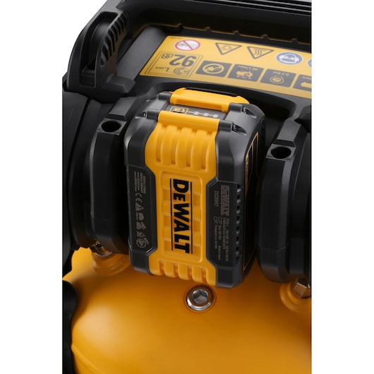 Close-up of a DEWALT battery attached to a portable device with yellow and black detailing.