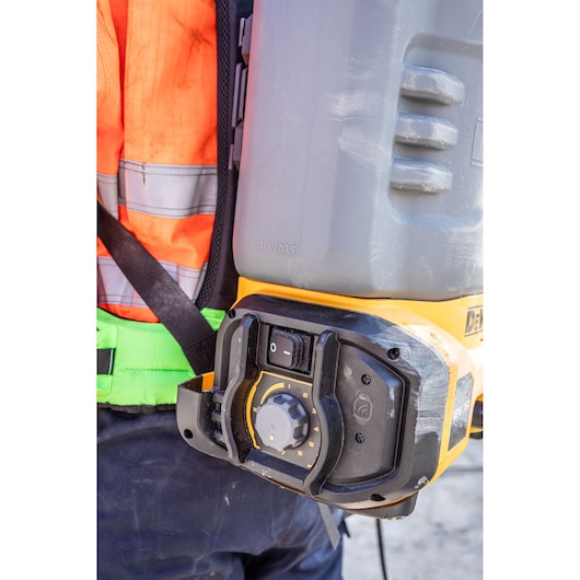 DEWALT DCCS1100N-XJ, DCCS1100N tool shown worn by worker; close up of controls on construction site.