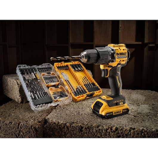 DEWALT cordless drill with drill bit sets in cases, placed on concrete blocks in a workshop setting.