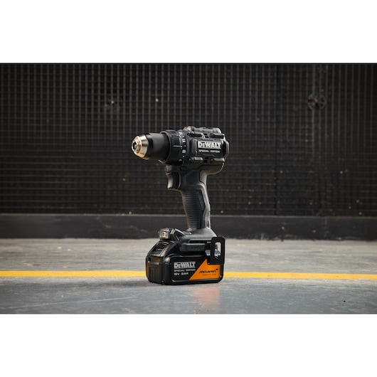 DEWALT cordless drill, black special edition, shown standing on a workshop floor with a grid background.
