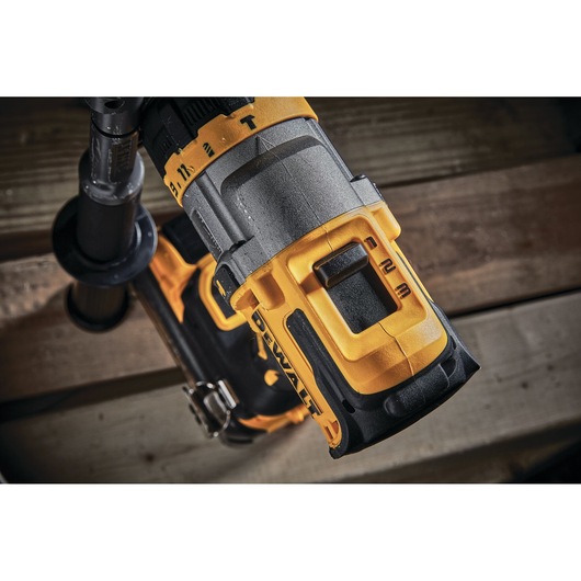 Close-up of a DEWALT cordless power drill showing control features and sturdy design, with yellow and black construction, placed on a wooden surface.