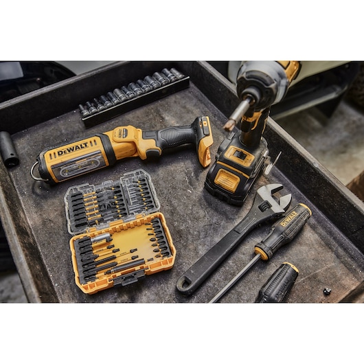 DEWALT tools and accessories, including driver, wrench, and bit set, displayed on a workbench.