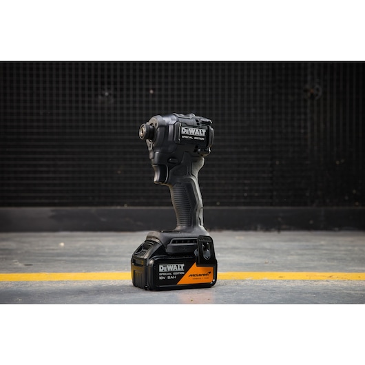 DEWALT Special Edition cordless impact driver with McLaren branding, standing on a workshop floor.