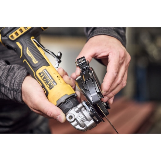 DEWALT DCG404NT, DCG404S2T-QW grinder in use, close-up of hand adjusting tool.