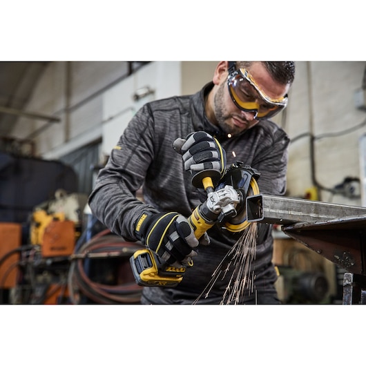 DEWALT DCG404S2T-QW, DCG404S2T in use, grinding metal, sparks flying, photography product, shown in workshop.