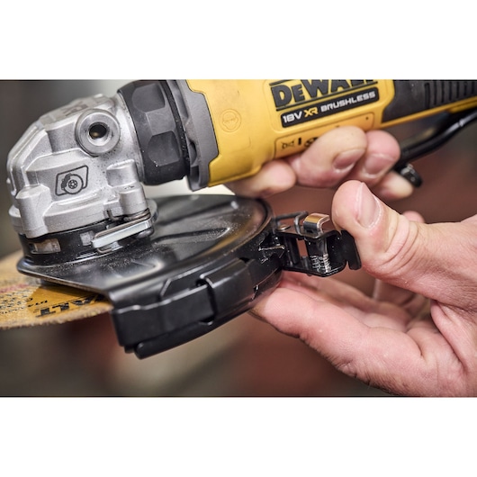 DEWALT angle grinder DCG404S2T-QW, DCG404S2T in use, close-up of guard adjustment.