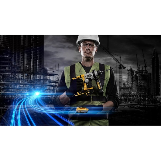 Worker holds a DEWALT cordless drill at a construction site with city buildings and blue light streaks in background.