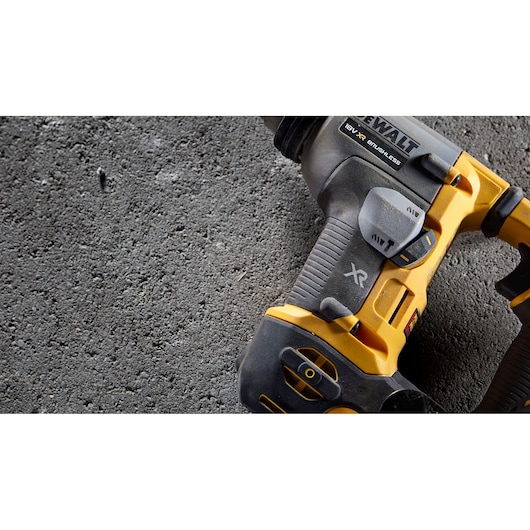 Close-up of DEWALT cordless drill on textured concrete surface.