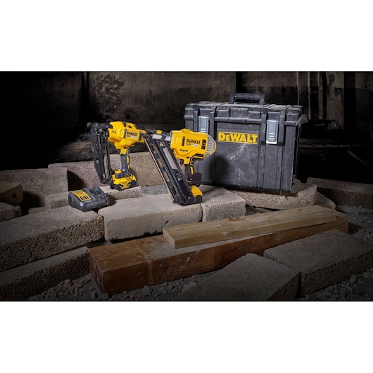 DEWALT cordless nailers set with two yellow and black nailers, battery charger, and a black carry case displayed on concrete