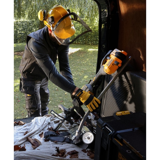 DEWALT DCMASED57X1, DCMASED9N tools handled by worker outdoors, shown with safety gear, photography category.