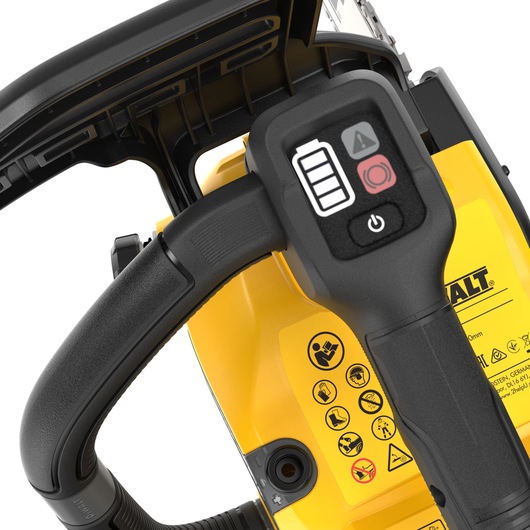 Close-up view of the handle and control panel of a DEWALT cordless chainsaw, showing battery indicator, warning symbols, and power button with detailed safety icons on the yellow body.