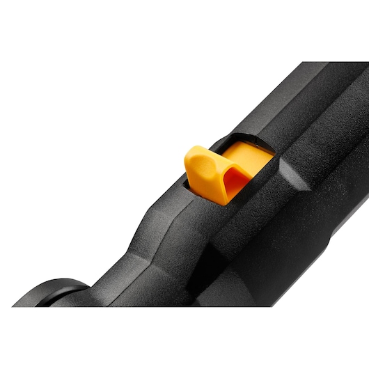 Close-up of a yellow switch on a black DEWALT tool handle, showing textured surface and detail.