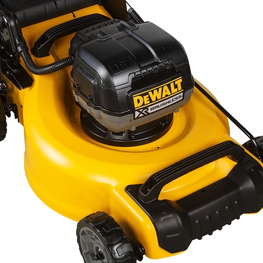 Close-up view of a DEWALT XR Brushless lawn mower, showing the battery compartment and handle. The mower features a yellow body and black accents.
