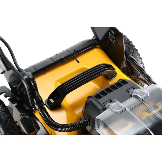 Close-up of a DEWALT lawn mower handle and battery compartment, featuring yellow and black plastic parts.