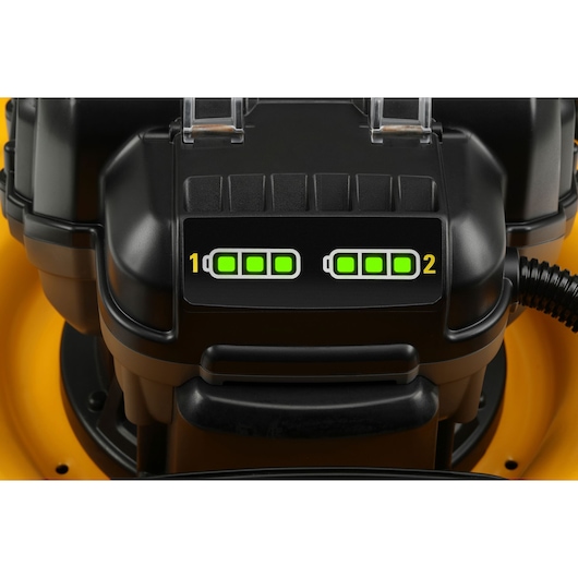 Close-up of DEWALT lawn mower showing two battery indicators both fully charged with bright green lights.