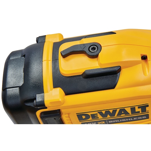 Close-up of a yellow and black DEWALT brushless power tool showing part of its handle and control switch.