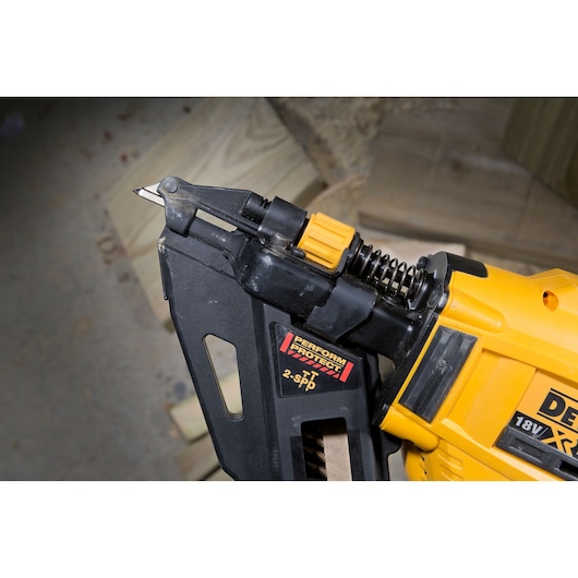 Close-up of a DEWALT DCN693N 18V XR nail gun, showing the Perform & Protect label and detailed view of the front mechanism and trigger.