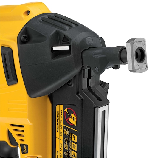 Close-up of a DEWALT yellow and black power tool with metal attachment and safety warning labels.