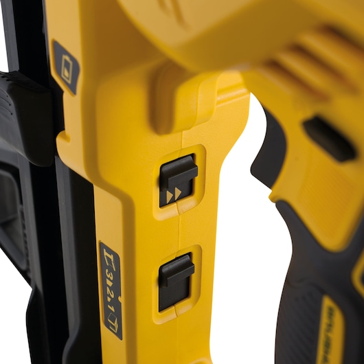 Close-up view of the side controls on a yellow and black DEWALT power tool, showing switches and part of the handle.