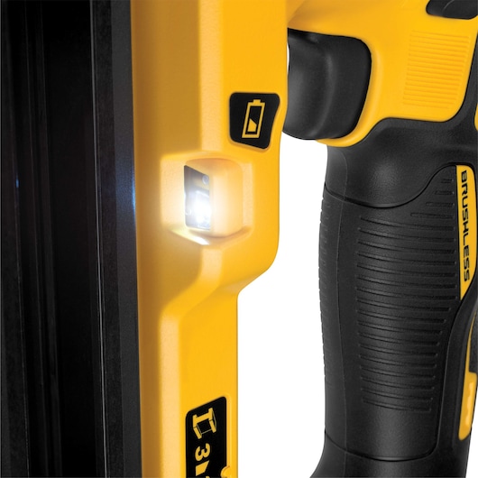 Close-up view of a DEWALT power tool handle, highlighting a bright LED light, textured black grip, and yellow casing with labeled indicators.