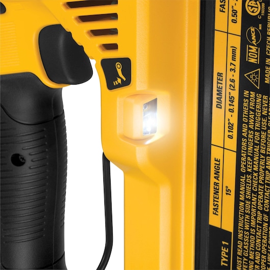 Close-up of a DEWALT power tool handle showing a black grip, a yellow body with vent slots, a small LED light, and safety instructions in English printed on the tool.