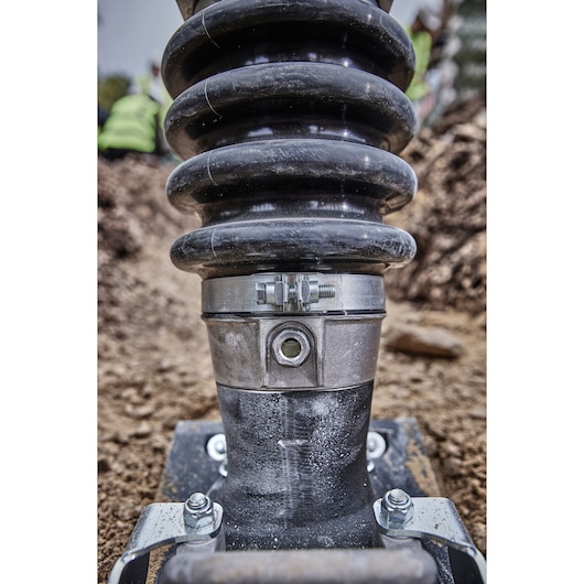 Close-up of a DEWALT machine part with metal and rubber, taken outdoors at a construction site.