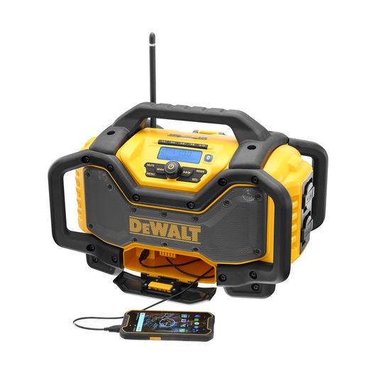 Yellow DEWALT radio with handle, speakers, and phone connected via cable. Built for durability and portable use.