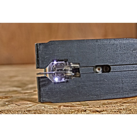 Close-up view of the blade and LED lights of a DEWALT jigsaw, model DCS334P2, while cutting through a piece of wood.