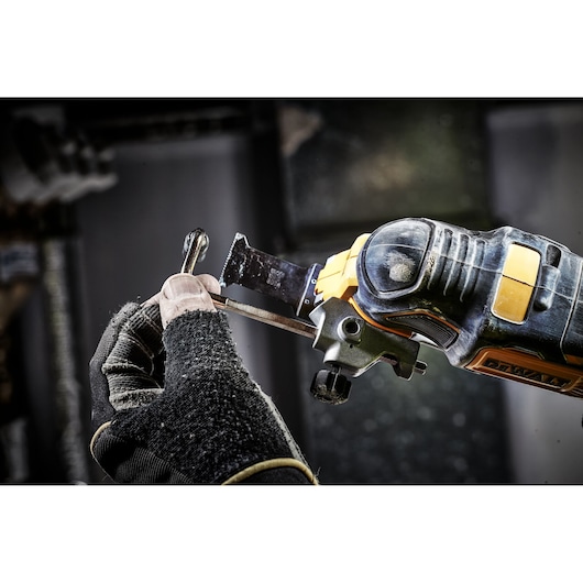 A close-up image shows a gloved hand using a DEWALT DCS356N oscillating multi-tool to cut a metal object.