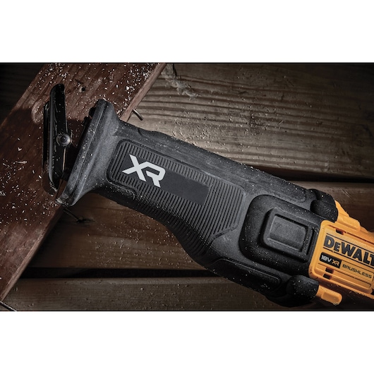 DEWALT cordless reciprocating saw cutting wood, showing XR 18V brushless design.