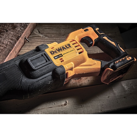DEWALT cordless 18V reciprocating saw resting on wood, yellow and black design, brushless model DCS386NT.