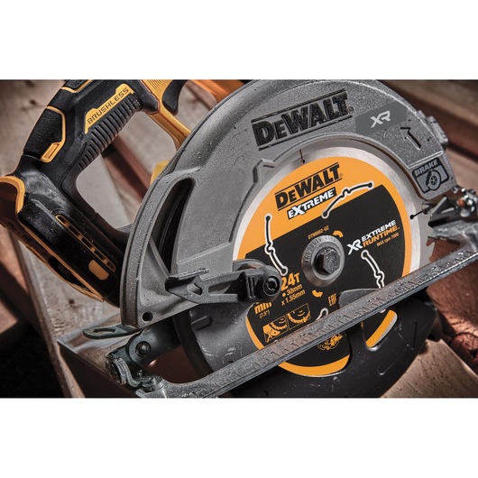 DEWALT DCS573NT cordless circular saw with brushless motor, shown close up on a wooden surface.