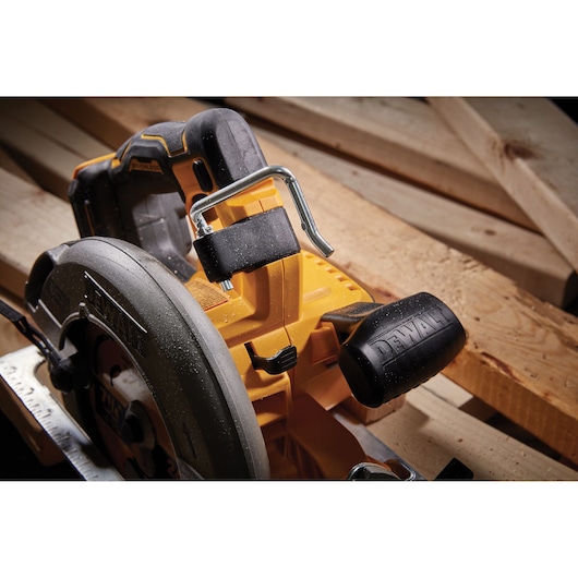 Close-up of a DEWALT circular saw placed on wooden planks, highlighting the blade and handle.