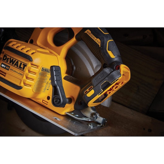 Close-up of a DEWALT 18V XR brushless cordless circular saw in use, showing handle and blade guard.