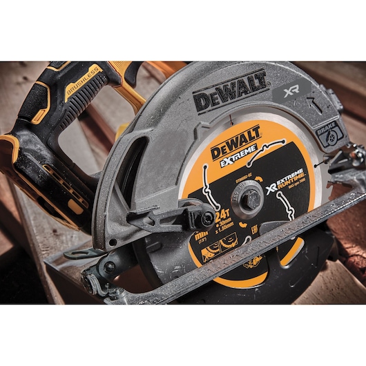 Close-up of a DEWALT DCS573T1 XR circular saw with brushless motor on a wooden surface.