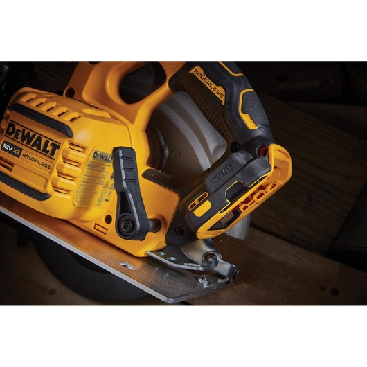 Close-up of a DEWALT 18V XR brushless circular saw in use on a wooden surface.