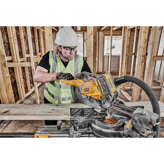 DEWALT DCS781X2-QW, DCS781X2 saw in use on construction site, worker cutting wood. Photography category.