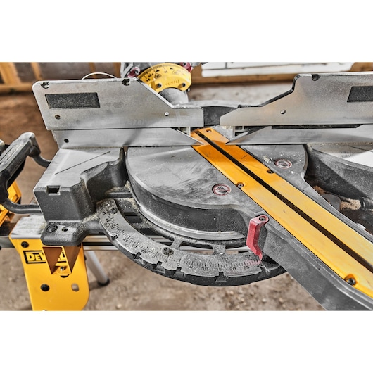 DEWALT miter saw DCS781X2-QW, DCS781X2 for photography; close-up of saw table and angle adjustment.