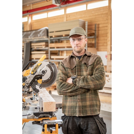 DEWALT DCS782N saw and person in workshop with wood, person’s face blurred for privacy.