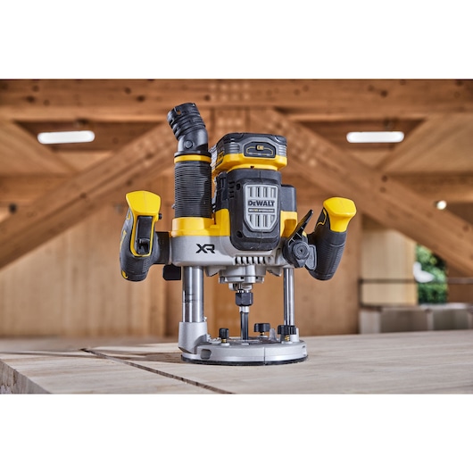 DEWALT cordless router placed on a wooden table in a workshop setting.