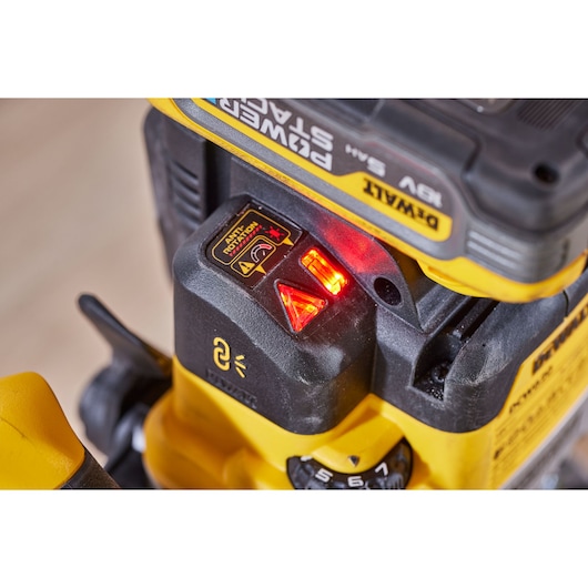 Close-up of DEWALT DCW620H2 tool with illuminated red indicator lights and battery installed.