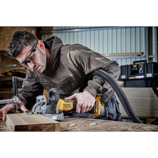 DEWALT jointer DCW682P2-QW, DCW682P2 in use on wood, in workshop. Photography product category.