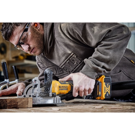 DEWALT tool in use for woodworking. Photography category. SKUs: DCW682P2-QW, DCW682P2.