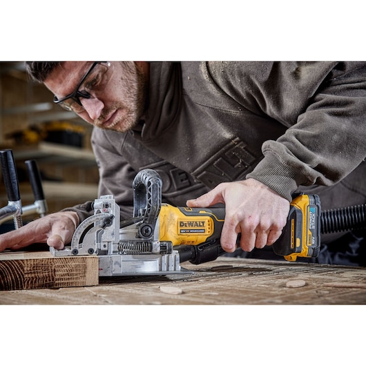 DEWALT tool used on wood, shown with DCW682P2-QW and DCW682P2 SKUs in workshop setting.