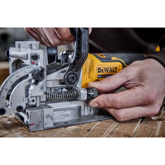 DEWALT tool in use, model DCW682P2-QW and DCW682P2, close-up of adjustment on photography product.