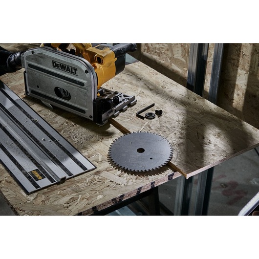 DEWALT saw with a guide rail and blade on a wood board, shown in a workshop setting.