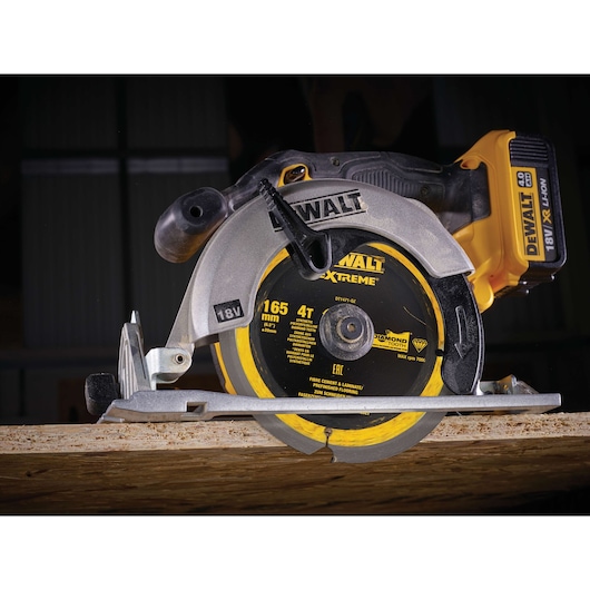 DEWALT 18V cordless circular saw cutting wood, model DT1471, close-up of blade and battery.