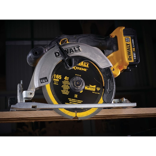 DEWALT DT1471 cordless circular saw cutting wood, 18V battery, 165mm blade, close-up view.